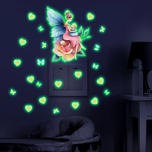 Luminous fairy and butterfly wall stickers glowing in a dark bedroom setting