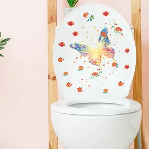 Detailed view of luminous butterfly and rose stickers on a white toilet lid surface