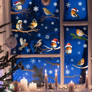 Detail of Christmas window clings featuring birds in hats and white snowflakes on glass