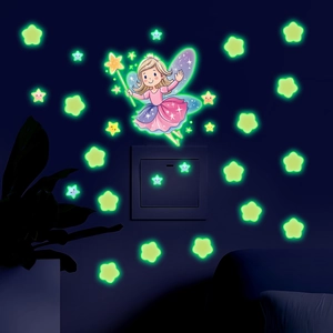 Luminous fairy and stars wall stickers glowing in green light on dark bedroom walls