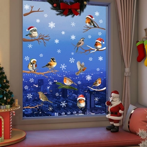 Detailed Christmas window stickers with birds, pine branches, and snowflakes on a night window