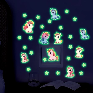 Luminous wall stickers featuring cartoon unicorns and stars glowing in a dark kid's room