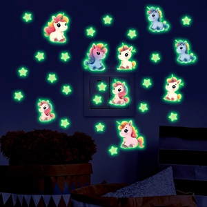 Glow-in-the-dark unicorn and star wall stickers showing luminous green effect in dark room