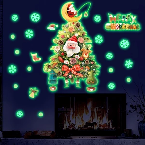 Luminous Christmas tree and Santa wall stickers glowing in green light on dark fireplace