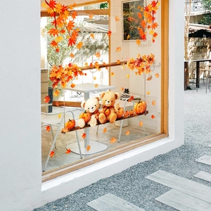 Detail of cute cartoon bears on a swing with maple leaves and pumpkins window sticker
