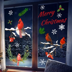Detail of red cardinal birds and snowflake static stickers on a dark glass window