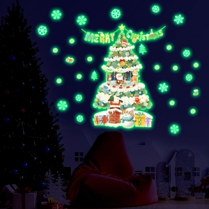Luminous Christmas wall sticker set with glowing tree and snowflakes in dark room setting