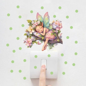 Détail du sticker mural fée des fleurs lumineuse avec des pois verts près de l'interrupteur