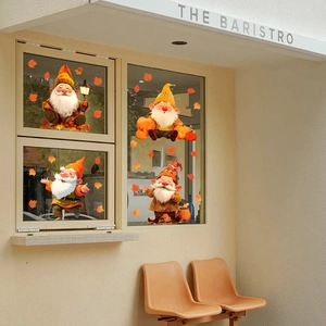 Detail of fall gnome window clings with pumpkins and maple leaves on a glass window