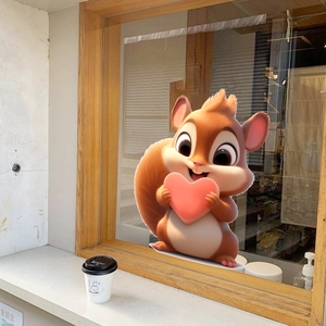 Close-up of cute orange squirrel window sticker with heart on glass background