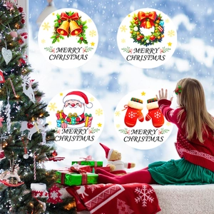 Gros plan de stickers de Noël ronds avec Père Noël et cloches sur une fenêtre festive