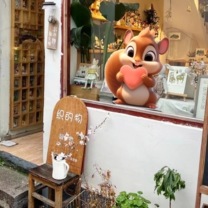 Detail of cute 3D cartoon squirrel holding a pink heart on a cozy shop windowsill