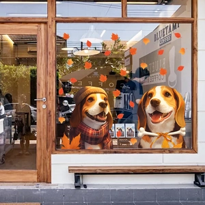 Detail of beagle dog window stickers and orange maple leaves on a glass window