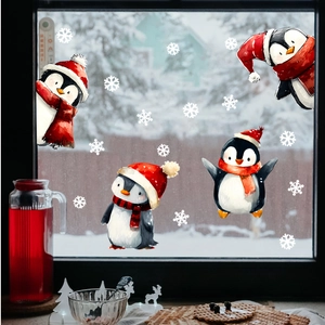 Close-up of festive Christmas penguin window stickers with snowflakes on glass pane