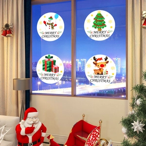 Vue détaillée de quatre stickers de Noël ronds sur vitre avec fond de ville nocturne