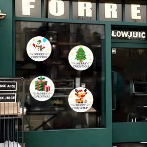 Détail de quatre stickers de Noël ronds avec motifs bonhomme de neige, renne et sapin
