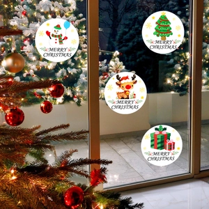 Gros plan de quatre stickers de Noël ronds avec bonhomme de neige et renne sur vitre