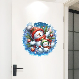Detail of a round Christmas snowman wall sticker displayed on a white interior door