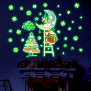 Glow-in-the-dark Christmas wall stickers showing Santa and tree on a dark blue wall