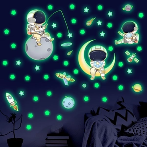 Glow in the dark wall stickers showing cartoon astronauts and stars in a child's bedroom