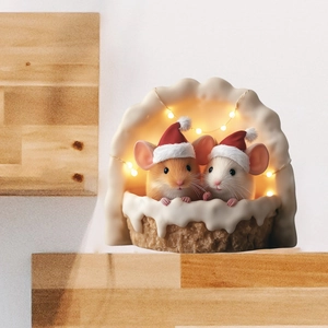 Close-up of festive Christmas mice figures with warm LED light in a snowy scene