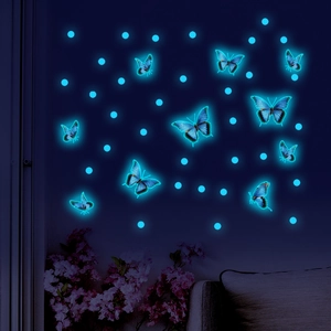 Luminous blue butterfly and dot wall decals glowing in a dark room setting