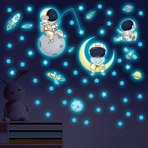 Luminous space astronaut wall stickers with moon and stars glowing in a dark room