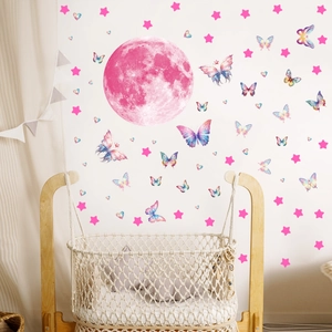 Pink glowing moon, colorful butterflies and stars wall stickers in a cozy nursery bedroom