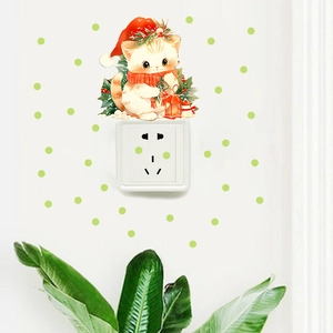 Detailed view of a Christmas cat wall sticker with Santa hat above a light switch decoration