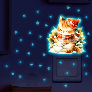 Luminous wall stickers showing blue glow cat, snowman and snowflakes in dark room