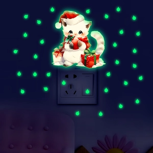 Luminous wall sticker showing glowing Christmas cat and gift boxes in dark bedroom