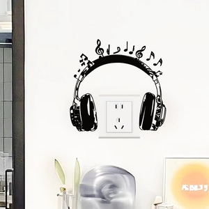 Detail showing black PVC headphone and musical note wall sticker around a power socket