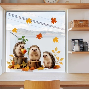 Detail of autumn hedgehog window decals with maple leaves on a bright glass pane