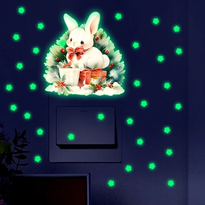 Luminous wall stickers showing a glowing white rabbit and green stars in a dark room setting