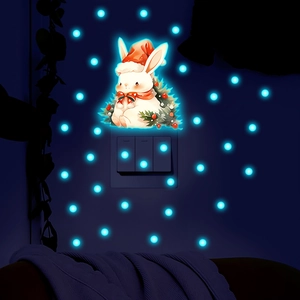 Glow-in-the-dark Christmas bunny wall stickers around a light switch in a dark room