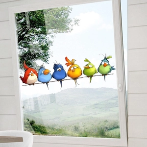 Colorful cartoon birds window clings on glass with a scenic mountain background view