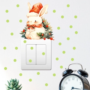Detail of cartoon white rabbit wall sticker with Christmas hat above light switch