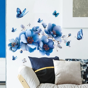 Blue floral wall decals with butterflies on white wall above modern living room sofa