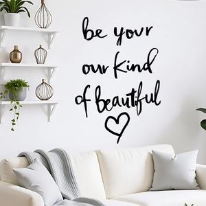 Détail d'un sticker mural inspirant avec citation manuscrite et cœur sur mur blanc