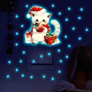 Luminous Christmas cat wall decals showing blue-green glow effect on bedroom wall
