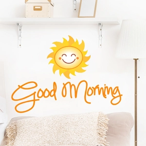 Détail du sticker mural soleil Good Morning dans une chambre avec meubles blancs