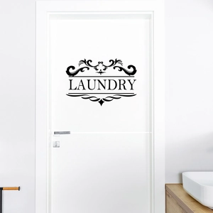 Close-up of black LAUNDRY vinyl door sticker with elegant floral pattern on white door