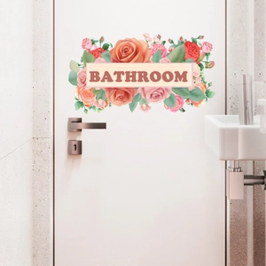 Close-up of floral bathroom door decal with roses and Bathroom text on white door