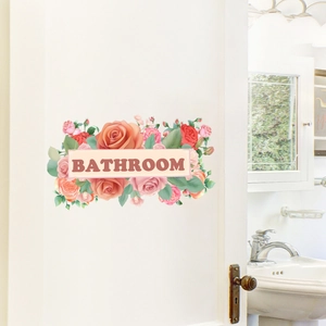 Close-up of floral wall sticker with pink roses and Bathroom text on white door