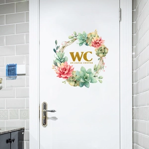 Floral succulent wreath WC door sticker with gold text on a white wooden door