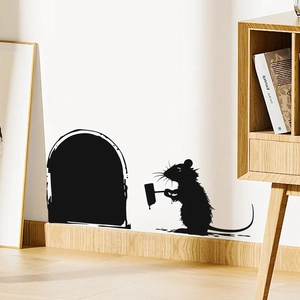 Detail of creative black mouse hole wall sticker featuring a silhouette mouse at a skirting board