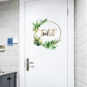 Detail of tropical leaf wreath toilet door sticker with golden typography for home decor