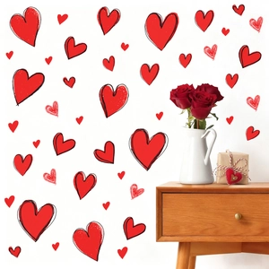 Red heart wall stickers set with various sizes on white wall above a wooden cabinet