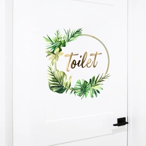 Detailed view of creative green leaf wreath toilet door sticker on white door surface