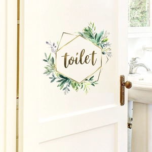 Detail of floral golden hexagonal toilet door sticker on white wooden door surface